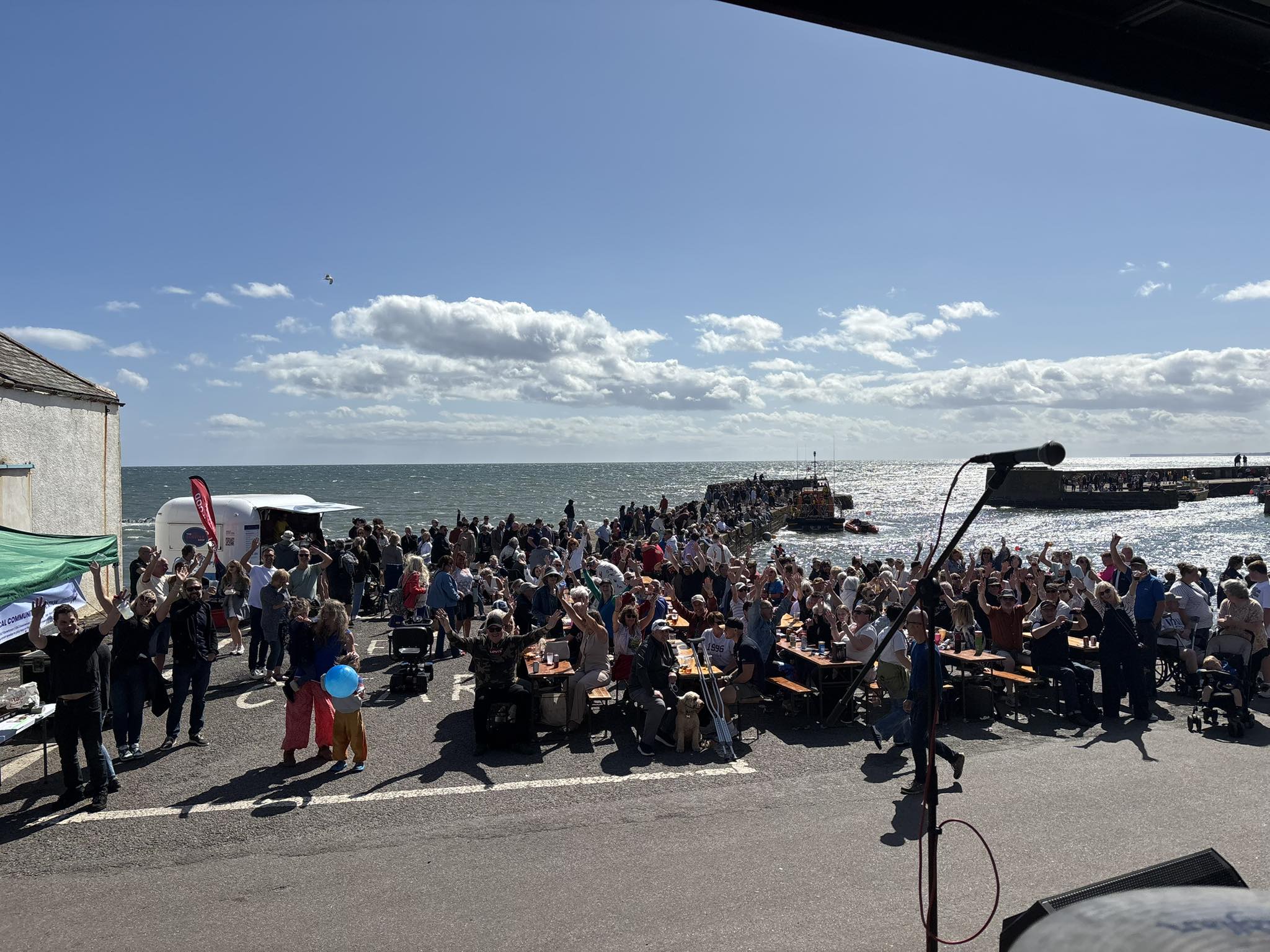 Audience sitting quay side at Johnshaven for the the Fish festival